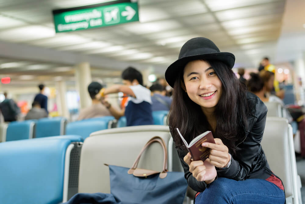 Asian student at the airport with passport
