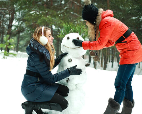 students building a snowman in Christmas